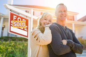happy couple with SOLD sign